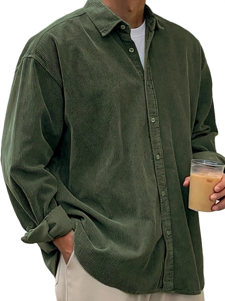 Person wearing a green corduroy shirt holding a drink.