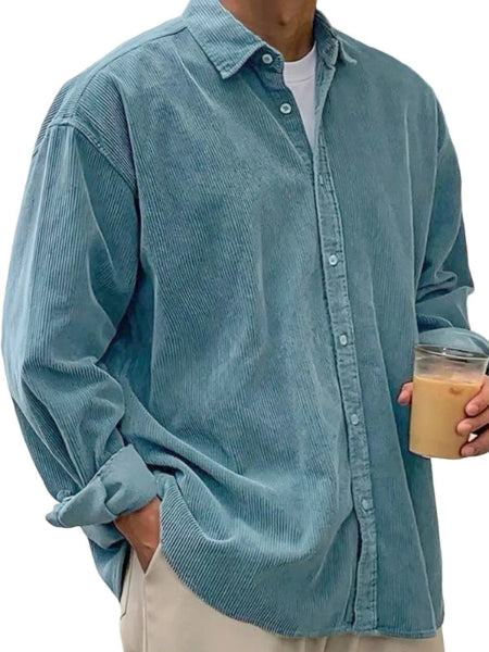 Person wearing a light blue corduroy shirt holding a drink.