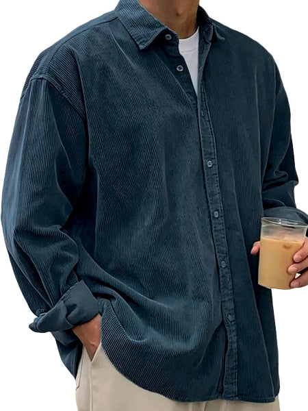 Person wearing a blue corduroy shirt holding a cup.