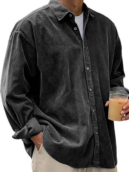 Person wearing a dark gray corduroy shirt holding a drink.