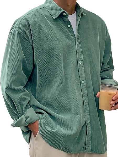 Person wearing a green corduroy shirt holding a drink.