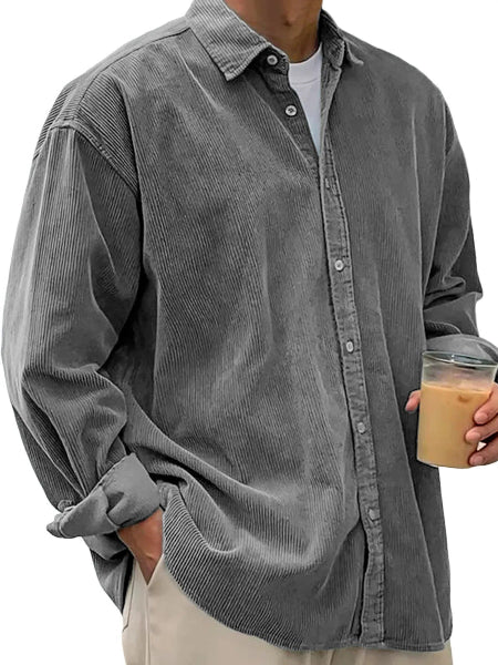 Person wearing a gray corduroy shirt holding a drink.
