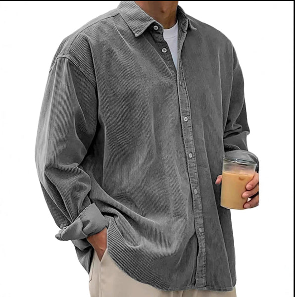 Person wearing a gray corduroy shirt holding a coffee cup on a white background