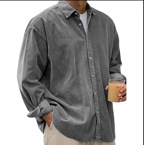 Person wearing a gray corduroy shirt holding a coffee cup on a white background