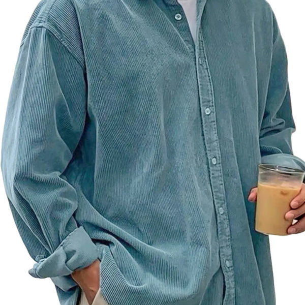Person wearing a light blue corduroy shirt holding a cup.