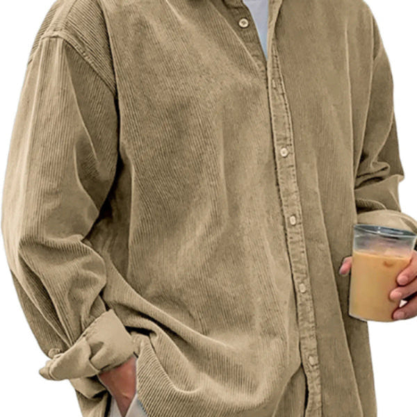 Person wearing a beige corduroy shirt holding a cup of coffee.